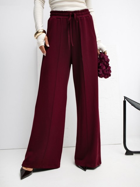 Bordowe joggersy z pionowymi przeszyciami masełko